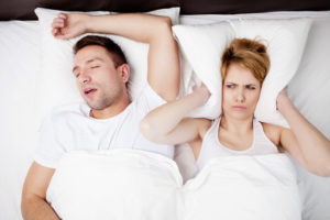Snoring man and woman in bed